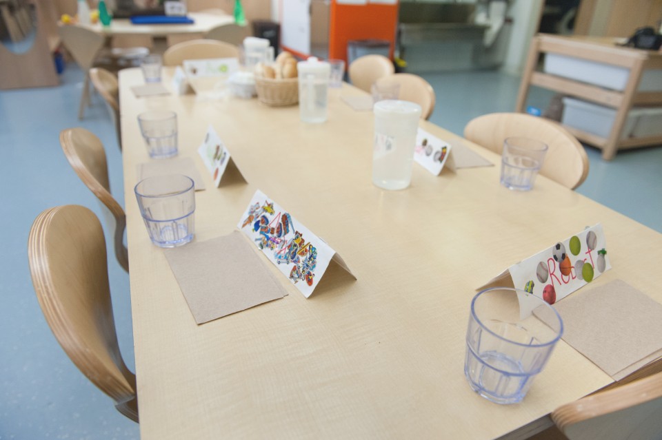 dining school table set with water glasses, place cards and chairs