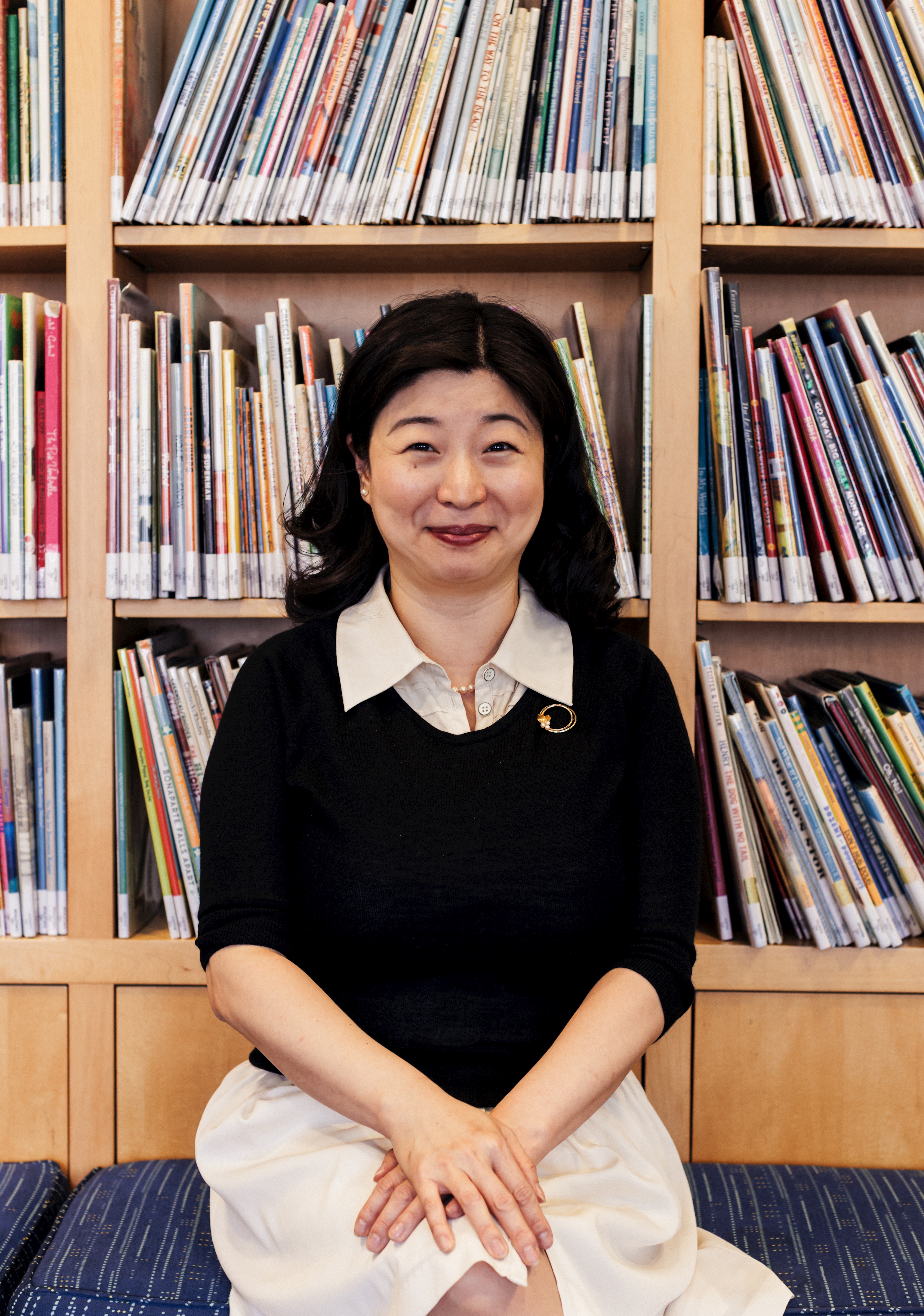 picture of female administrator in front of shelves full of books